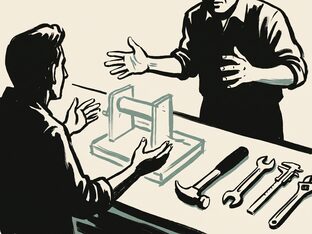 Two people at a workbench, the object between them still only a rough outline